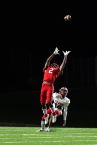 football player jumping with another one behind him